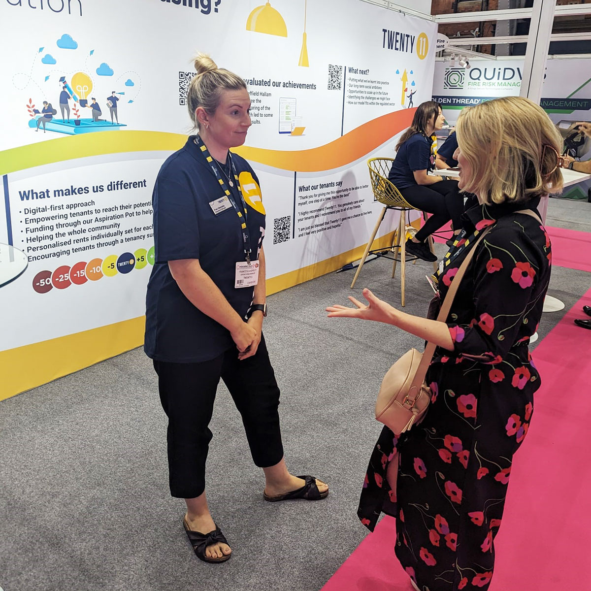 A member of the Twenty11 team in conversation with a visitor to the Housing 2023 conference in Manchester